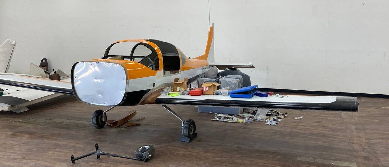 A small orange and white airplane sitting on top of the floor.